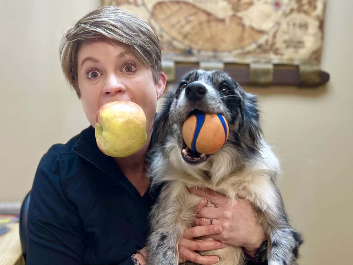 A woman sits beside her dog