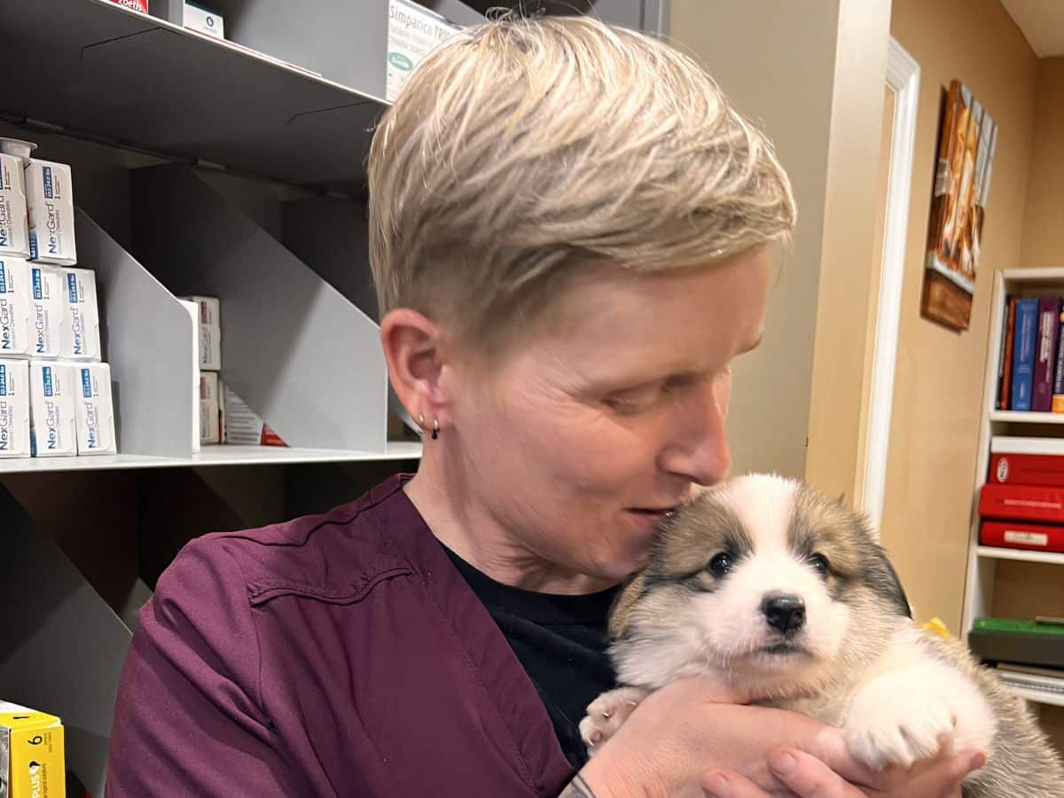 A woman cradles a small puppy in her arms